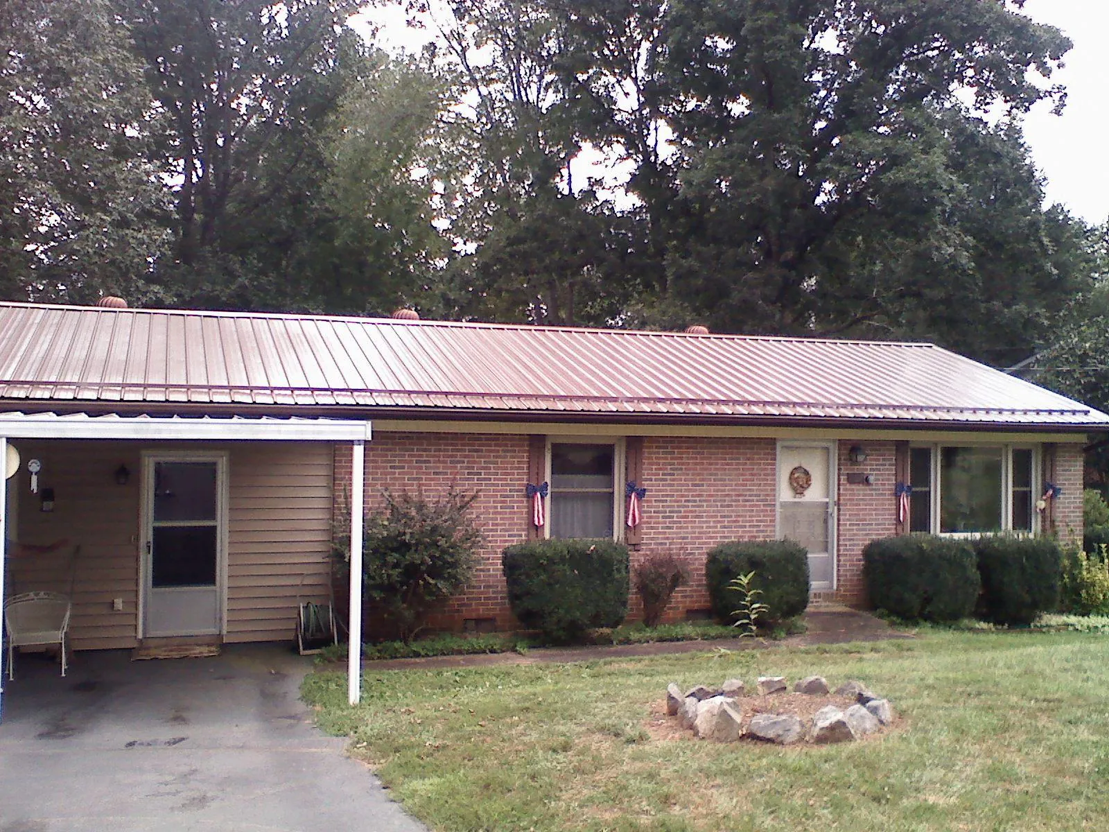 Bronze metal roof and carport on a brick ranch home — Roof Repair work by our crew in Graham